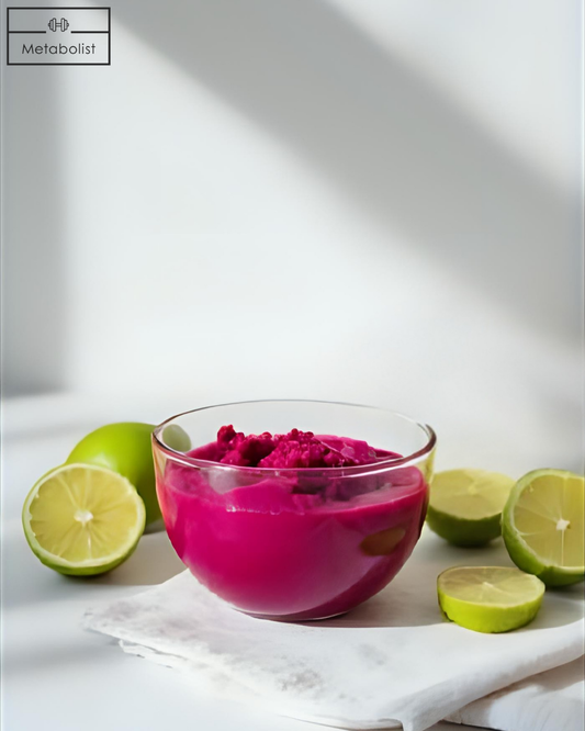 Glass bowl with pink substance surrounded by limes on a white surface