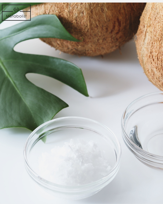 Clear glass bowl with white powder, green leaf, and coconuts on a light background