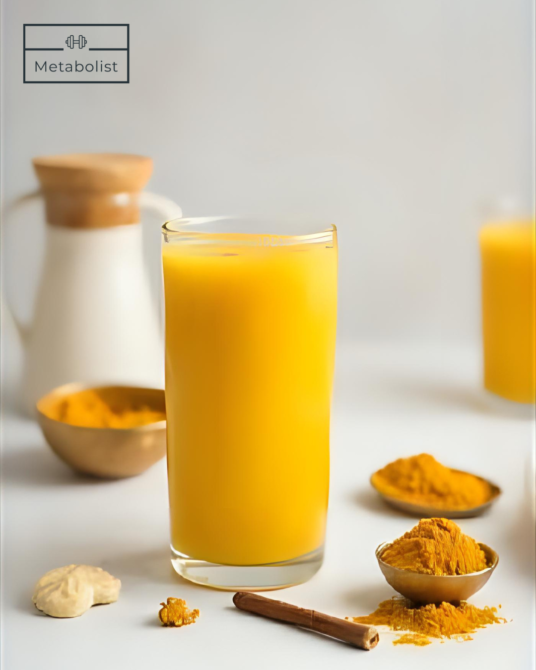 Glass of orange juice with turmeric, ginger, and cinnamon on a light background